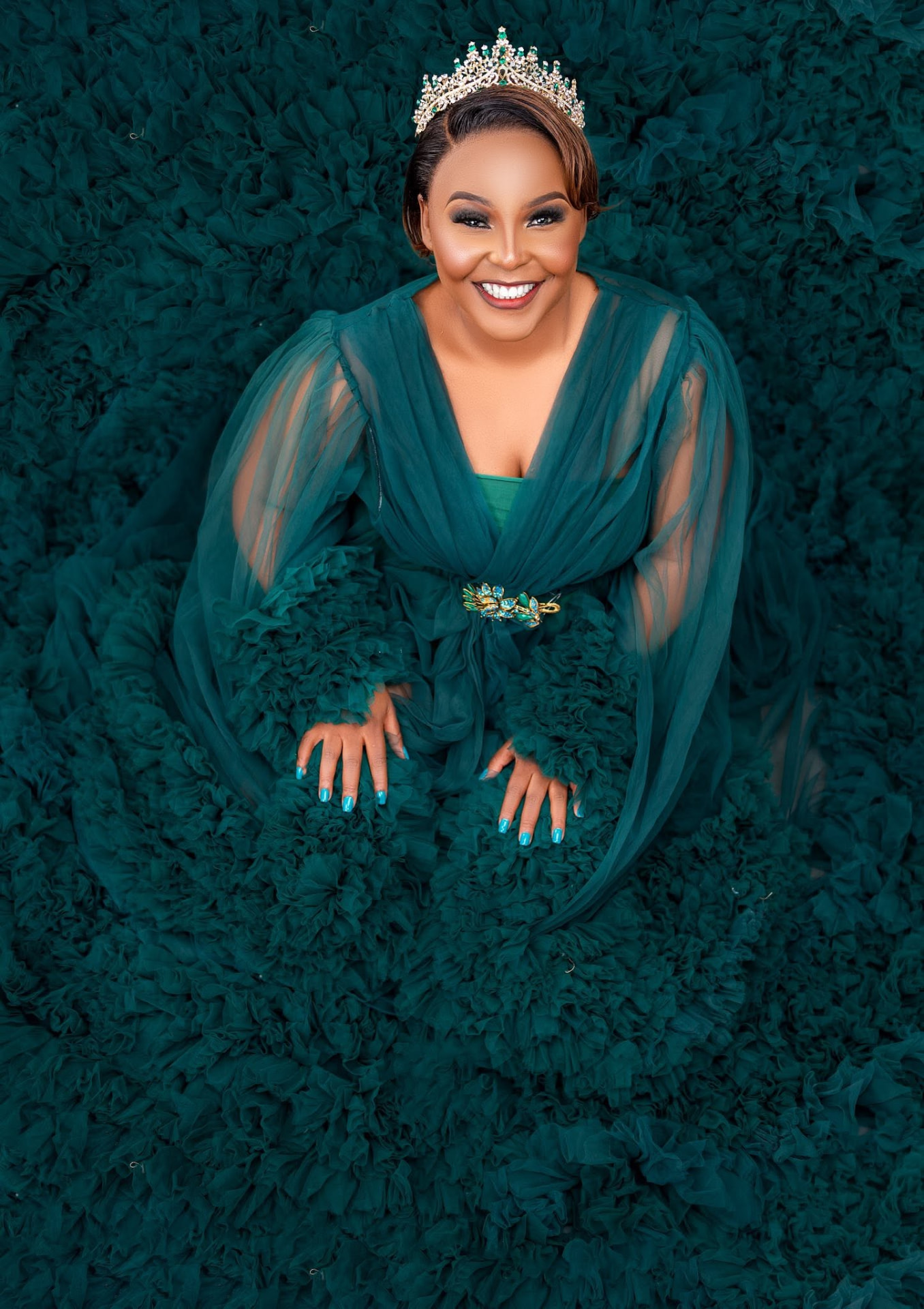 Maclean Sandra Phiri crowned, surrounded by teal tulle